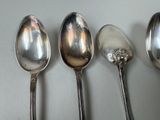 four spoons are lined up in a row on a table