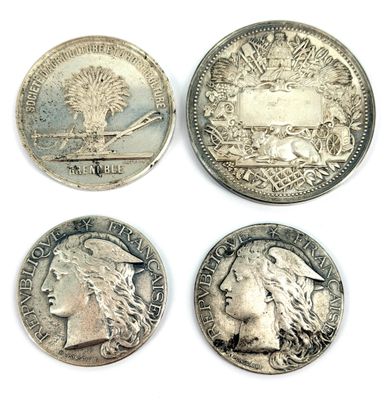 quatre types différents de pièces d'argent sur une surface blanche