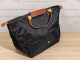 a black tote bag sitting on top of a wooden table