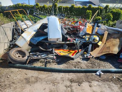 a pile of junk on the ground next to a fence