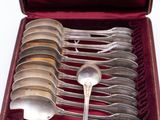 six spoons in a red case with a silver spoon in it