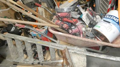 a wheelbarrow full of assorted items in a garage