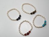 quatre bracelets ornés de perles et de pierres précieuses sont disposés sur un fond blanc