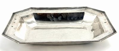 an antique silver plate on a white background with a reflection in the center