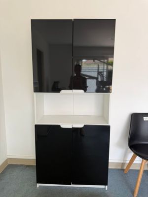 une armoire noire et blanche dans un coin de la pièce