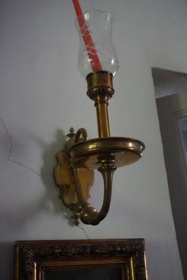 une bougie accrochée au mur à côté d'un cadre photo