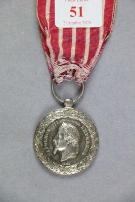 une médaille d'argent entourée d'un ruban rouge et une médaille d'argent entourée d'un ruban rouge