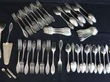 a lot of silver spoons and forks laid out on a table