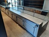 a counter with a glass top in the middle of a room