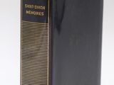 a black book with gold trim sitting on top of a white surface