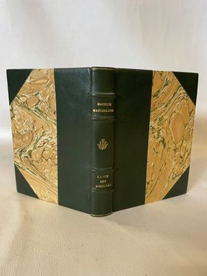 a black and gold book sitting on top of a white table