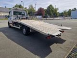 un camion blanc à plateau dans un parking