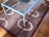 une table en verre posée sur un tapis dans le salon