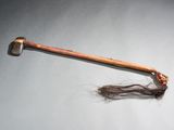 une vieille hache avec un long cheveu posé sur une table