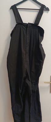 a black dress hanging on a hanger on the wall