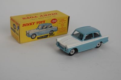 une petite voiture bleue et blanche à côté d'une boîte jaune