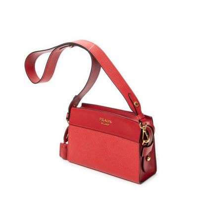 le petit sac rouge est posé sur une surface blanche