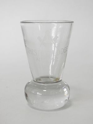 un verre transparent à fond plat posé sur une surface blanche