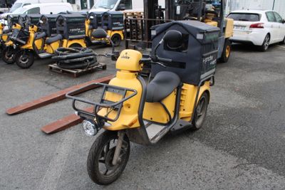 un scooter jaune et noir garé sur un parking