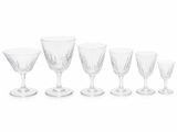 six wine glasses sitting next to each other on a white surface