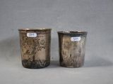 pair of silver cups with designs of birds and flowers on them