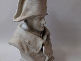 statue of a bust of a man with a hat on a book