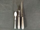 a knife, spoon, and spoon rest on a table