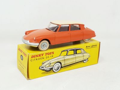 a red toy car sitting on top of a yellow box