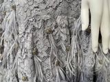 a mannequin wearing a dress with feathers on it