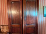 une armoire en bois devant laquelle se trouve une chaise