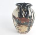 a vase with a painting on it sitting on a table