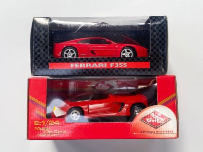 Une voiture miniature Ferrari F35 rouge dans une boîte, posée sur une surface blanche