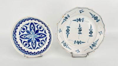 two blue and white plates with designs on them on a white surface