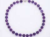 un collier composé de perles de verre violettes et muni d'un fermoir en argent