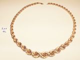 a close up of a gold necklace on a white surface