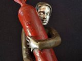 statue of a woman holding a red object on a black background