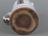 a brown and white vase sitting on a gray surface