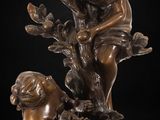 a bronze statue of a boy and girl sitting on a tree branch