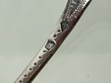 a silver spoon with a spoon handle on a white surface