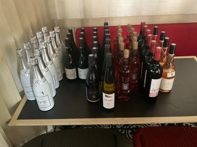 Des bouteilles de vin sont alignées sur une étagère devant une fenêtre