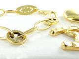 deux bracelets en or et une breloque en forme de cœur sur un fond blanc