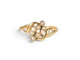 a close up of a gold ring with pearls on a white background