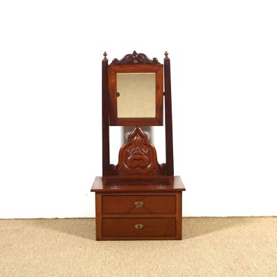 une petite commode en bois surmontée d'un miroir