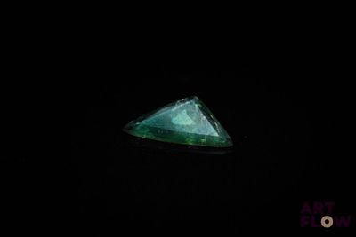 l'image d'un diamant vert de forme triangulaire dans l'obscurité