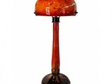 une photo d'une lampe de table surmontée d'un abat-jour en verre rouge