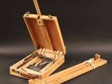 a small wooden box with tools in it on a black surface