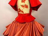 an orange dress on a mannequin with a red cape over it