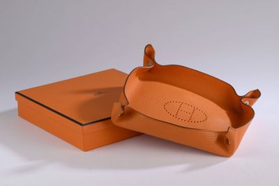 an orange box with a brown handle and a brown lid
