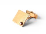 a close up of a gold cuff on a white background