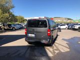a grey van parked in a parking lot next to other cars